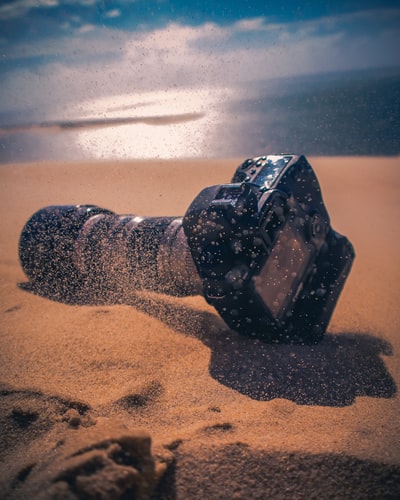 沙滩上的黑色单反相机
